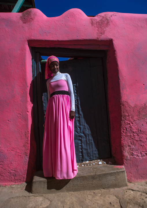 Beautiful teenage girl in pink in front of a doorway, Harari region, Harar, Ethiopia