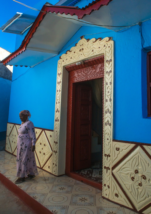 Woman in front of her old blue house, Harari region, Harar, Ethiopia