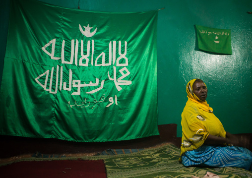 Sufi woman worshipper in front of islamic flag, Harari region, Harar, Ethiopia
