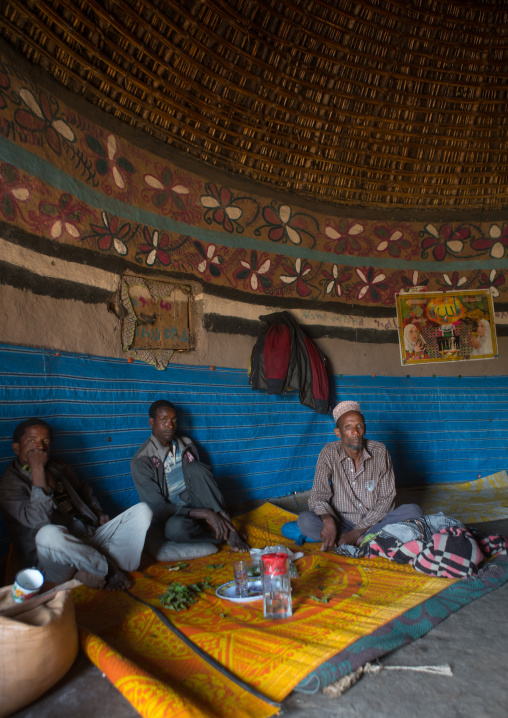 Ethiopia, Kembata, Alaba Kuito, men chewing khat inside their traditional house with decorated and painted walls