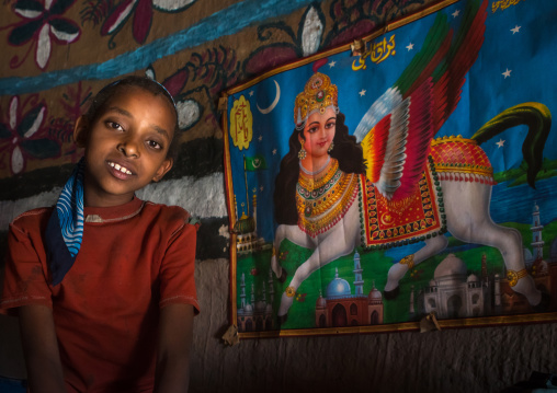 Ethiopia, Kembata, Alaba Kuito, girl in front of an al buraq winged horse poster inside her house
