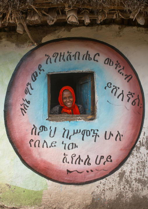 Ethiopia, Kembata, Alaba Kuito, ethiopian woman standing in the window of her traditional painted house