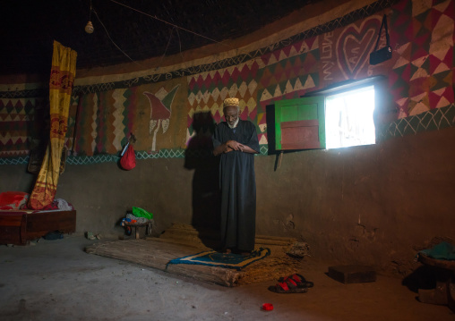Ethiopia, Kembata, Alaba Kuito, ethiopian muslim man praying inside his traditional painted and decorated house