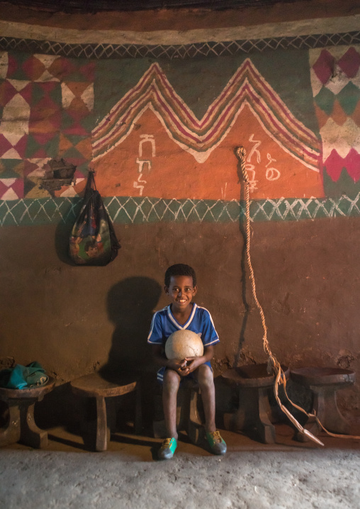 Ethiopia, Kembata, Alaba Kuito, ethiopian boy inside his traditional painted and decorated house