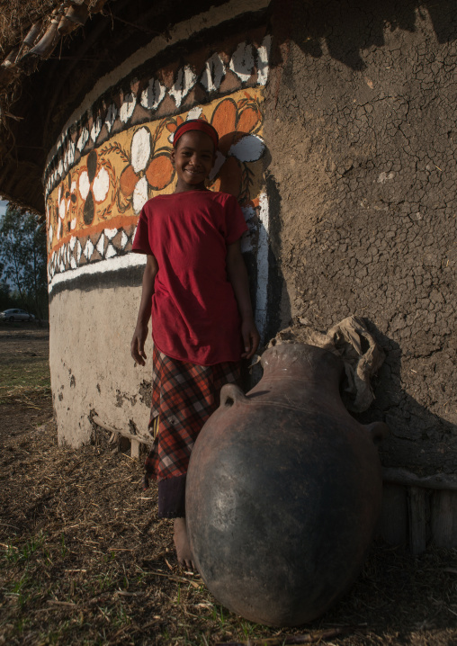 Ethiopia, Kembata, Alaba Kuito, ethiopian boy standing in front of his traditional painted house