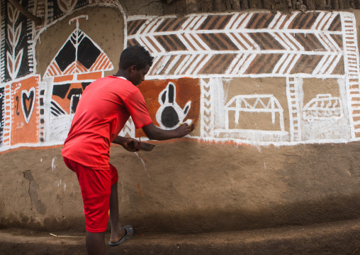 Ethiopia, Kembata, Alaba Kuito, young man painting the wall of a traditional ethiopian house