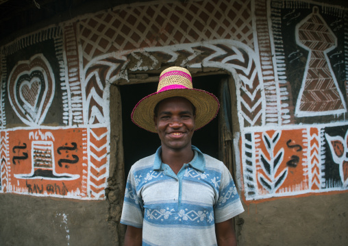 Ethiopia, Kembata, Alaba Kuito, ethiopian man with a hat standing in front of his traditional painted house