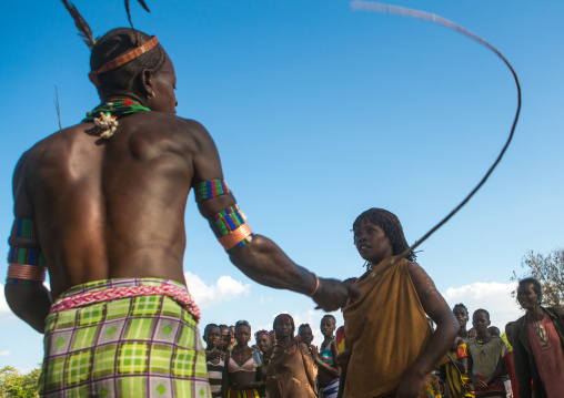 Hamer tribe maze whipping a woman during a bull jumping ceremony, Omo valley, Turmi, Ethiopia