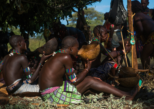 Hamer tribe whippers drinking alcohol during a bull jumping ceremony, Omo valley, Turmi, Ethiopia