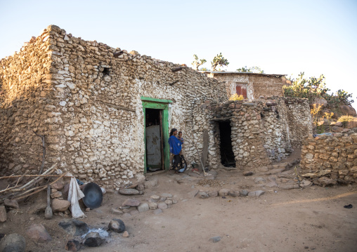 Ethiopian woman with her child in front of a traditional Argoba stone houses village, Harari Region, Koremi, Ethiopia