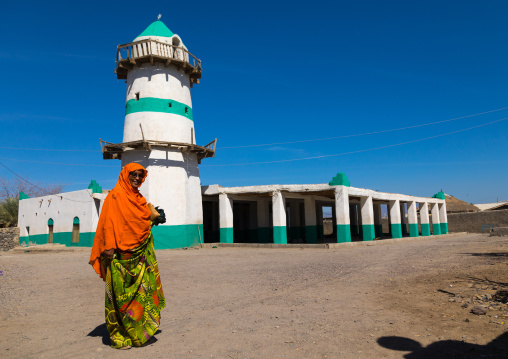 Afar woman in front of the sultan Alimirac Canfere mosque and its famous minaret, Afar region, Assaita, Ethiopia
