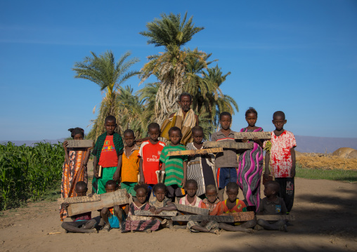 Afar tribe children with wood boards in a coranic school with their teacher, Afar region, Afambo, Ethiopia