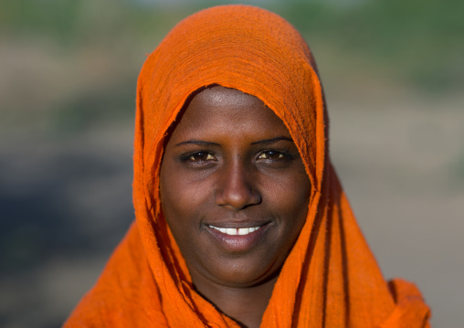 Portrait of a smiling Afar tribe woman with an orange veil, Afar region, Afambo, Ethiopia