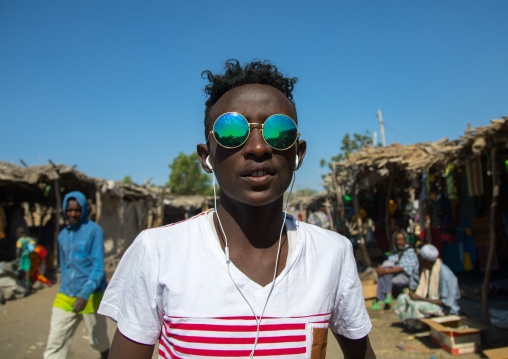 Portrait of an Afar tribe teenager with sunglasses in the street, Afar region, Assaita, Ethiopia