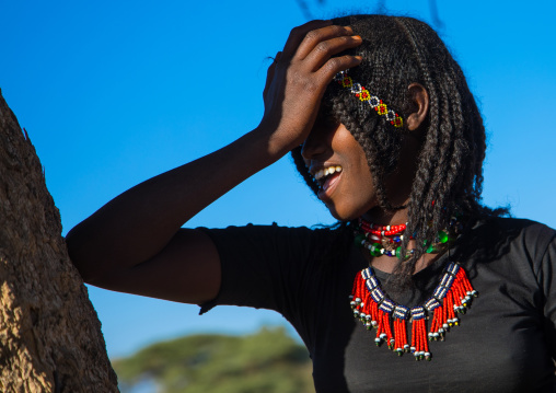 Portrait of an Afar tribe girl with braided hair laughing, Afar region, Chifra, Ethiopia