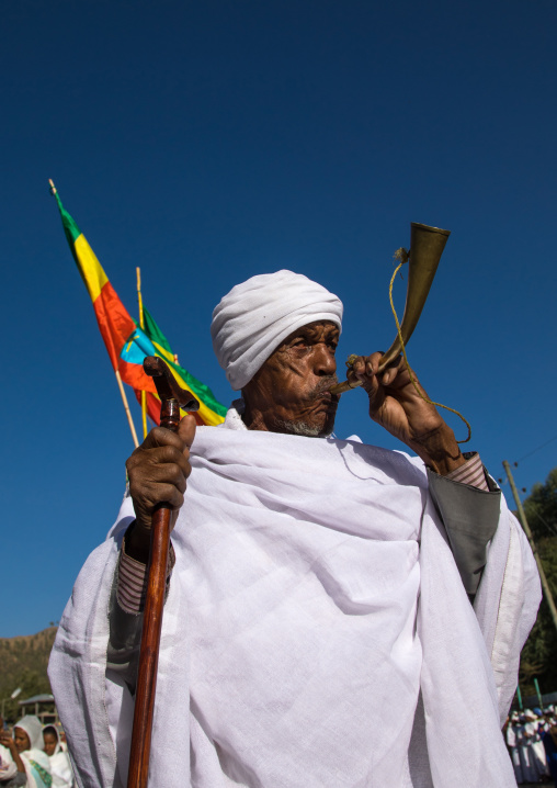 Ethiopian orthodox priest blowing in a horn during the colorful Timkat epiphany festival, Amhara region, Lalibela, Ethiopia