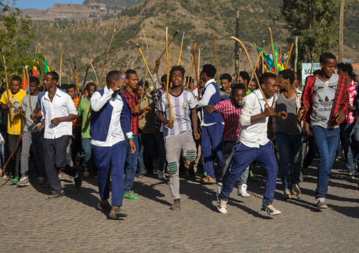 Ethiopian young men dancing and singing in the street with sticks during Timkat epiphany festival, Amhara region, Lalibela, Ethiopia