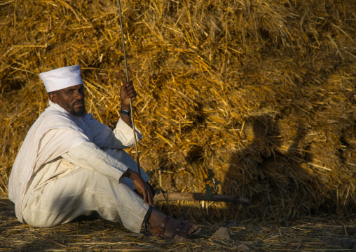 Orthodox ethiopian priest sitting in a field during Timkat, Amhara region, Lalibela, Ethiopia