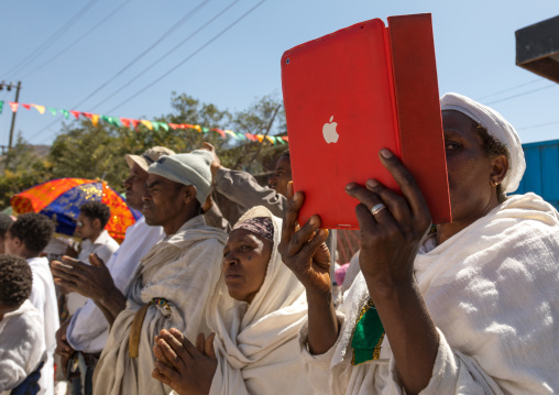 Ethiopian pilgrim taking pictures with her ipad during Timkat epiphany festival, Amhara region, Lalibela, Ethiopia