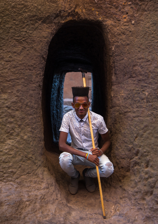 Young man with incredible gelled hair in a rock church, Amhara region, Lalibela, Ethiopia