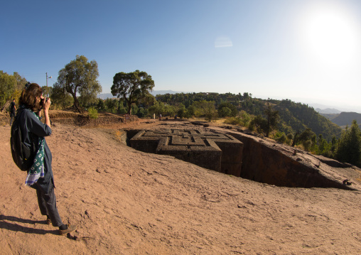Tourist taking picture of the monolithic rock-cut church of church of st. George , Amhara region, Lalibela, Ethiopia