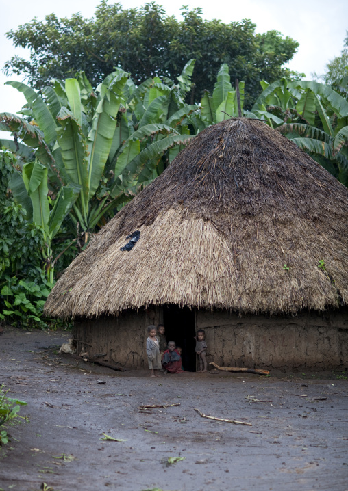 Young kids in the entrance of a traditional house, Ethiopia