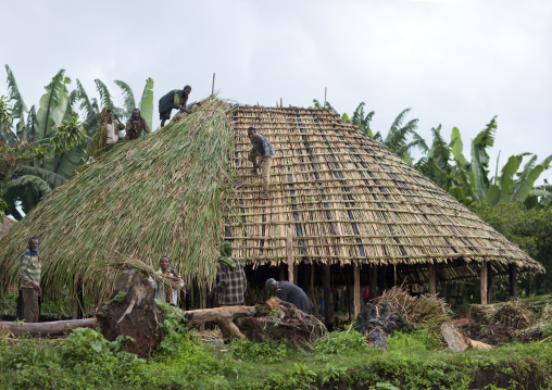 Men building the roof of a traditional house, Ethiopia
