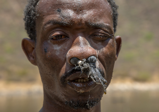 Borana tribe man with protection in his nose ready to dive in the volcano crater to collect salt, Oromia, El Sod, Ethiopia