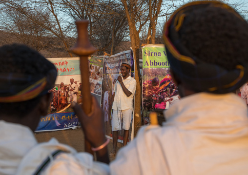 Man speaking in front of billboards during the Gada system ceremony in Borana tribe, Oromia, Yabelo, Ethiopia