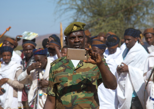 Soldier filming with his mobile phone during the Gada system ceremony in Borana tribe, Oromia, Yabelo, Ethiopia