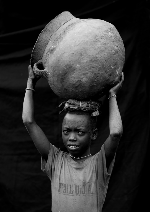 Menit boy carrying a jar on his head, Tum market, Omo valley, Ethiopia