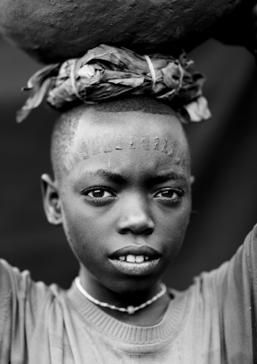 Menit boy carrying a jar on his head, Tum market, Omo valley, Ethiopia