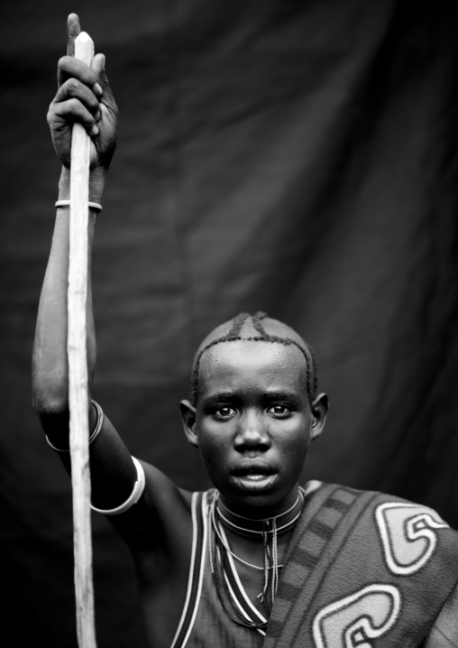 Menit young man holding a stick, Tum market, Omo valley, Ethiopia