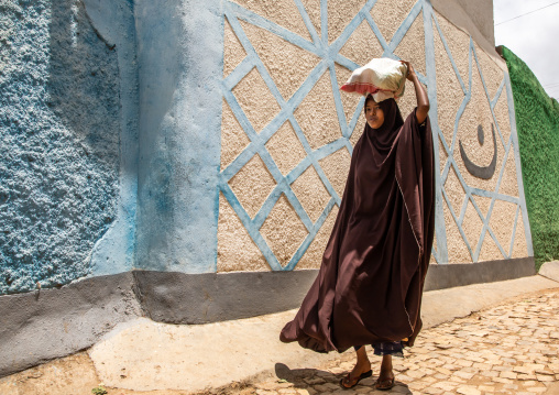 Ethiopian woman carrying a bag on her head in the street, Harari region, Harar, Ethiopia