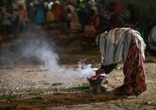 Oromo pilgrim woman burning insence during a ceremony, Oromia, Sheik Hussein, Ethiopia