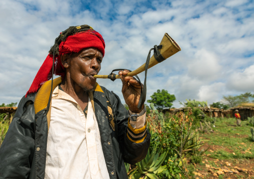 Oromo pilgrim man blowing in a horn during the pilgrimage, Oromia, Sheik Hussein, Ethiopia