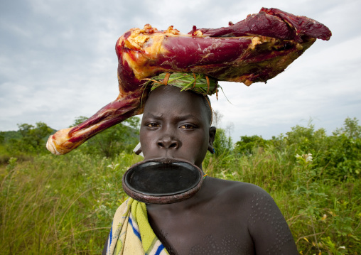Surma Girl With A Lip Plate Wearing Cow Meat On Her Head, Omo Valley, Ethiopia