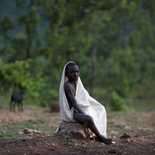 Suri boy sitting, Turgit village, Omo valley, Ethiopia