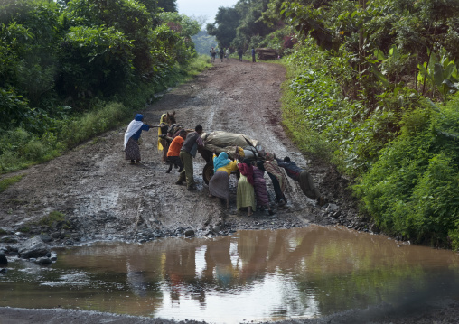 People pushing a trolley on a muddy slope, Ethiopia