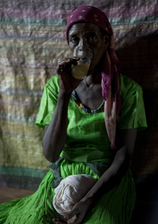 Woman sipping mead in a pub, Ethiopia