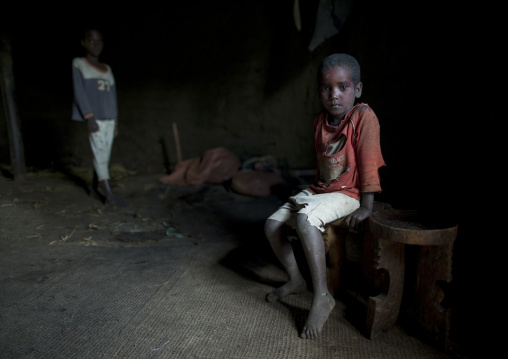 Boy on a bench inside a house, Gourague area, Ethiopia