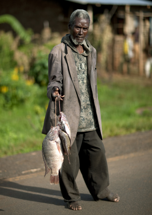 Man carrying fishes, Gourague area, Ethiopia