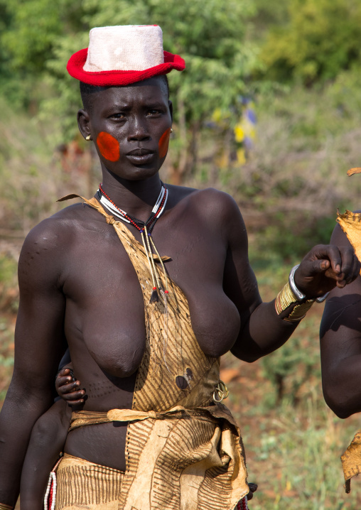 Woman with a hat during the fat men ceremony in Bodi tribe, Omo valley, Hana Mursi, Ethiopia