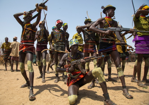 Men shooting with kalashnikovs during the proud ox ceremony in the Dassanech tribe, Turkana County, Omorate, Ethiopia