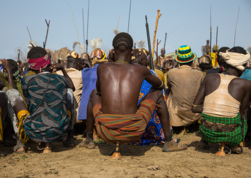 Tribe warriors during the proud ox ceremony in the Dassanech tribe waiting to share the cow meat, Turkana County, Omorate, Ethiopia