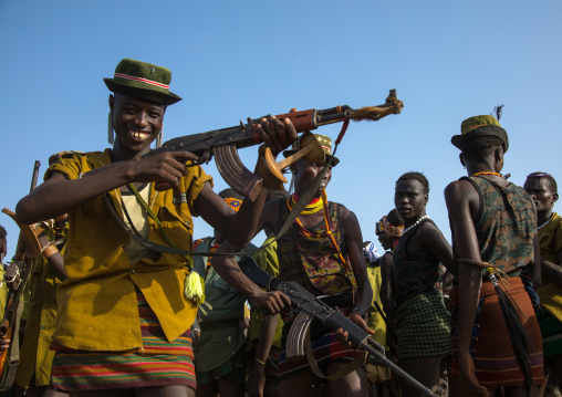 Man shooting with a kalashnikov during the proud ox ceremony in the Dassanech tribe, Omo valley, Omorate, Ethiopia
