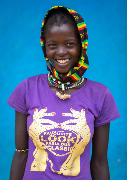 Portrait of a Bana tribe girl in front of a blue wall, Omo valley, Key Afer, Ethiopia