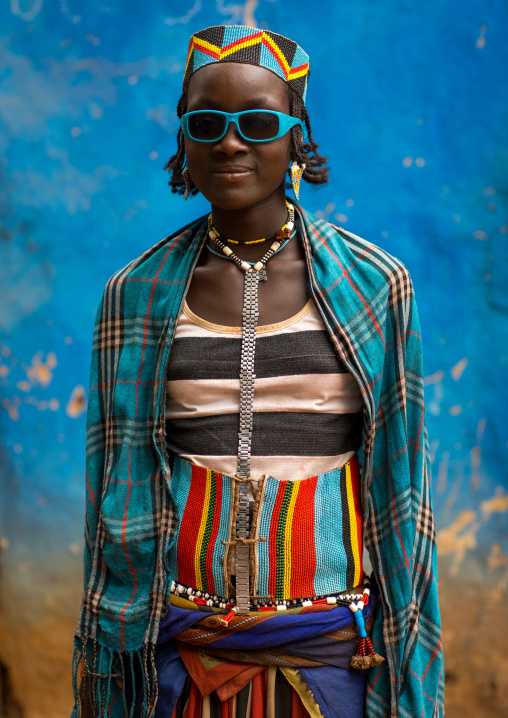 Portrait of a Bana tribe girl in front of a blue wall, Omo valley, Key Afer, Ethiopia