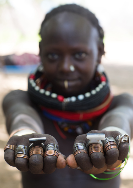 Sudanese Toposa tribe girl refugee showing her hand rings, Omo Valley, Kangate, Ethiopia