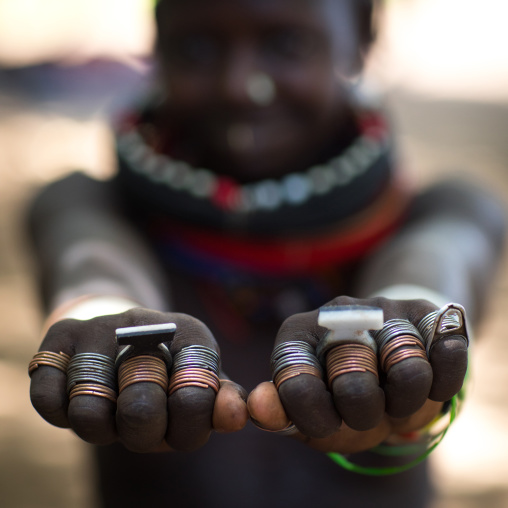 Sudanese Toposa tribe girl refugee showing her hand rings, Omo Valley, Kangate, Ethiopia